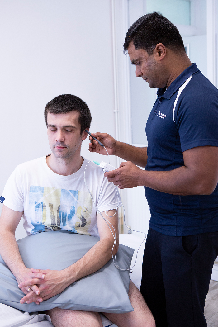 Physiotherapist using non-invasive nerve pain therapy 